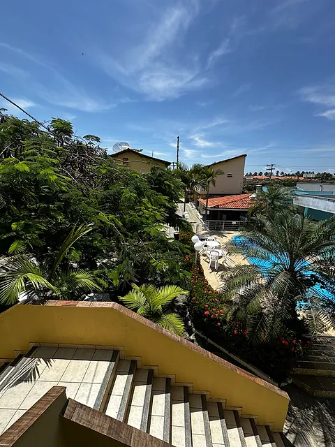 Escada com vista de cima para a piscina e o jardim