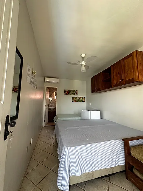 Quarto de casal com armário de madeira e ventilador