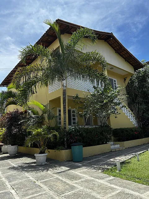 Bloco de quartos cercado por jardim e palmeiras